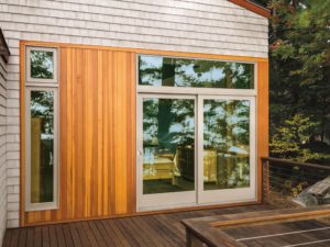 Modern sliding glass doors surrounded by wood siding
