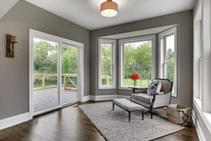 Bay window and sliding patio doors leading from sitting room to backyard deck